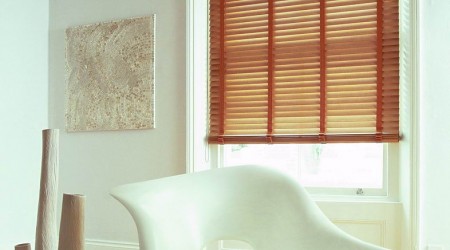 żaluzje poziome z lamelami z drewna szer. 50 mm zamontowane na oknie w salonie